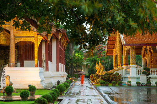 Monk walking under an umbrella at the Wat Phra Singh Temple, Chiang Mai, Thailand. Chiang Mai's most revered temple.