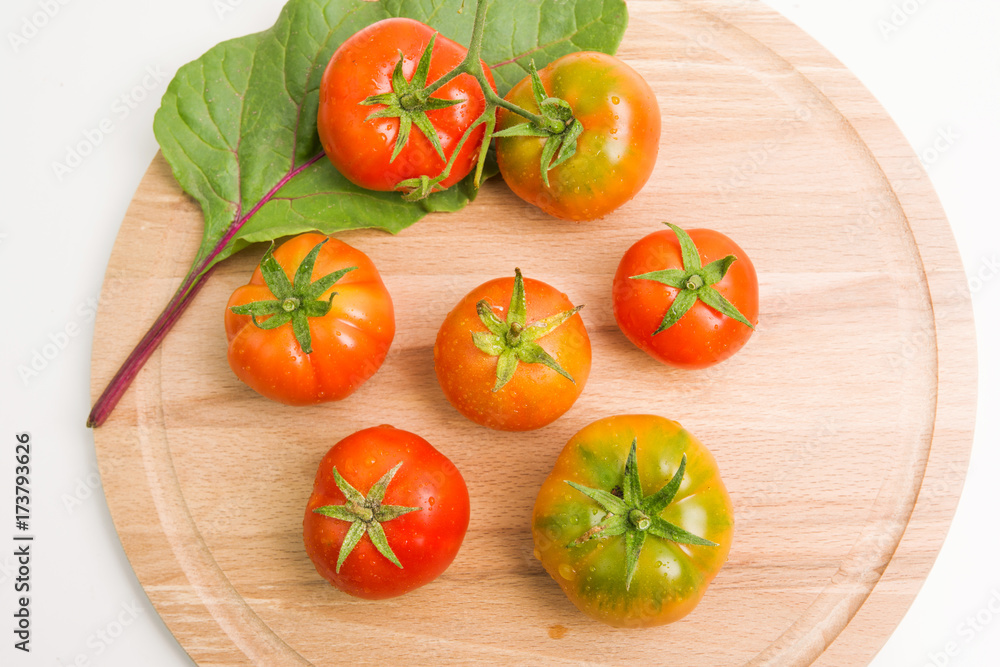 Fresh Tomatoes From The Garden On Wooden Plate Closeup Top View Fresh Tomatoes From The Garden On Wooden Plate Closeup Top View