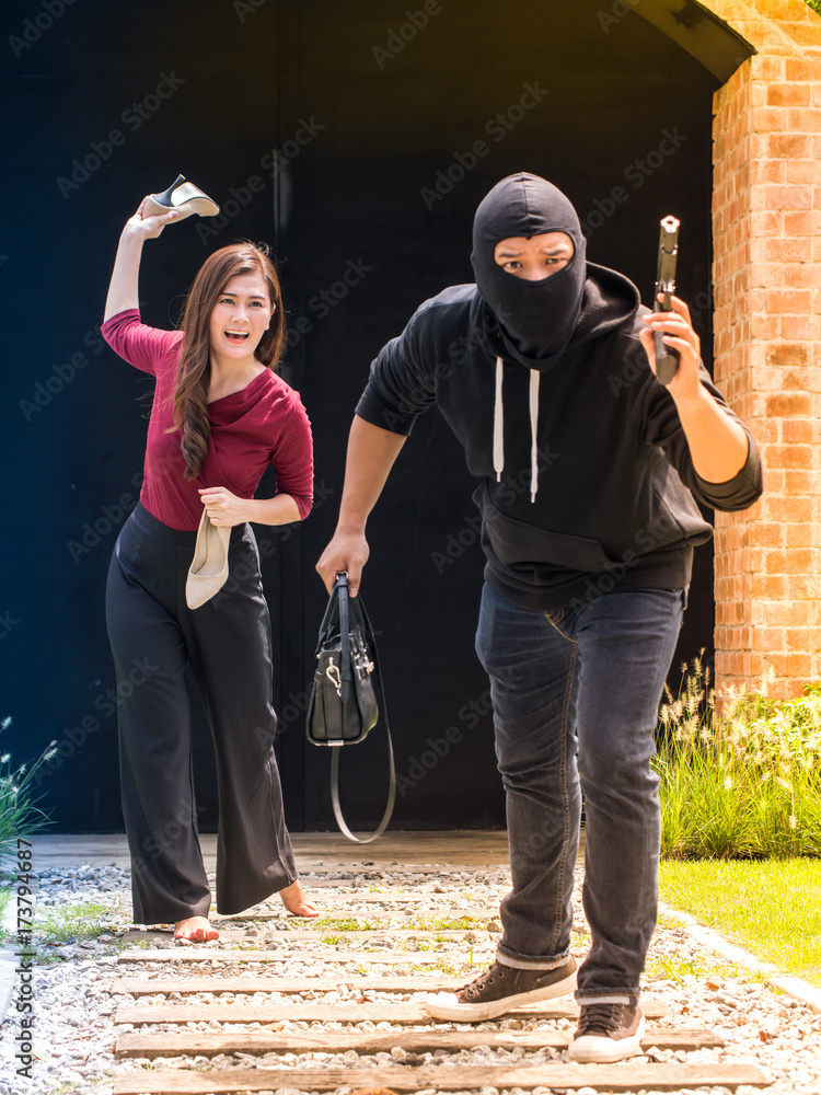 Foto Stock Beautiful woman throwing her shoes to the thief, who stole