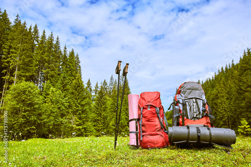 Backpacks in the mountains overlooking the mountains on the green grass. photo