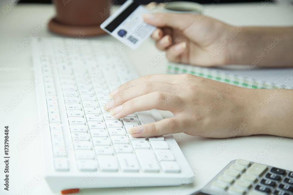 Woman hands holding a credit card and using computer keyboard Woman hands holding a credit card and using computer keyboard