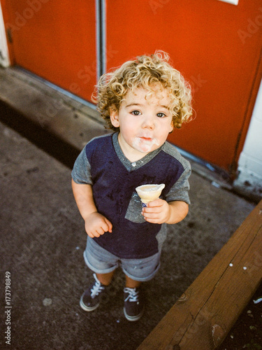 little boy looks up eating ice cream photo