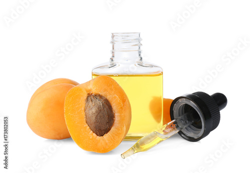 Bottle of apricot oil with fresh fruit on white background