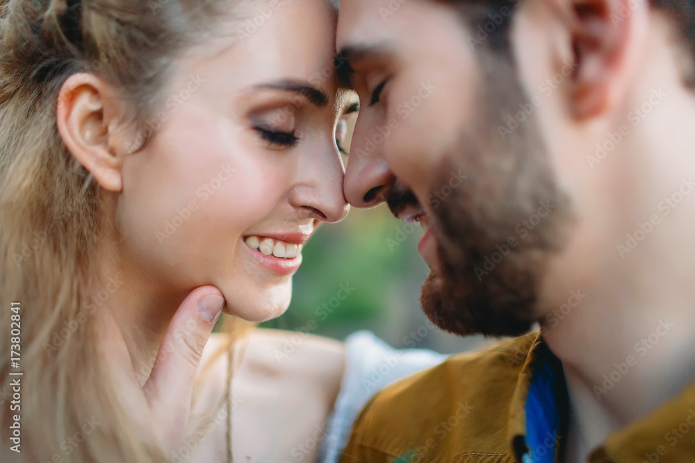 A young couple smile and touching foreheads with closes eyes. Autumn wedding ceremony outdoors. Bride and groom look at each other with tenderness and love. Close-up portrait A young couple smile and touching foreheads with closes eyes. Autumn wedding ceremony outdoors. Bride and groom look at each other with tenderness and love. Close-up portrait