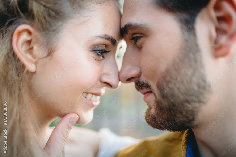A young couple smile and touching foreheads. Autumn wedding ceremony outdoors. Bride and groom look at each other with tenderness and love. Close-up portrait A young couple smile and touching foreheads. Autumn wedding ceremony outdoors. Bride and groom look at each other with tenderness and love. Close-up portrait