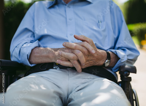 Happy, fun loving elderly couple outside in garden using wheelch photo