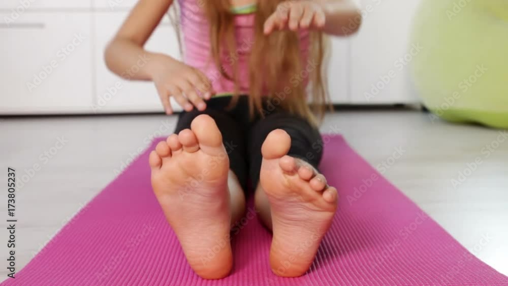 Young girl exercising at home - doing stretching gymnastic ... 