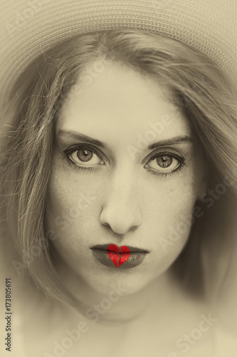 Fototapeta Naklejka Na Ścianę i Meble -  Black and white photography of a beautiful girl in a hat and broken heart shape on a lips