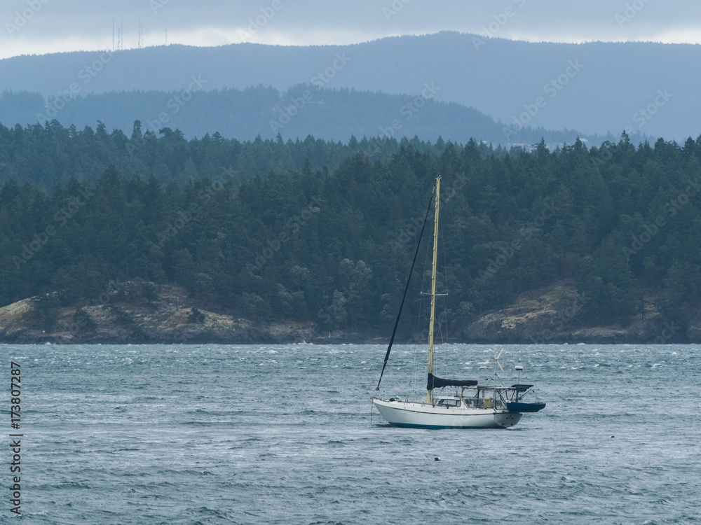 a white silboat crusing on sea against cloudy sky a white silboat crusing on sea against cloudy sky