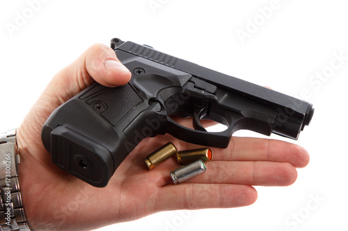 Gun with patrons in man hand on white background