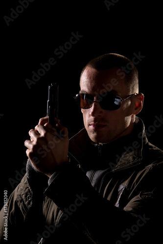 detective or criminal with gun on foggy night background