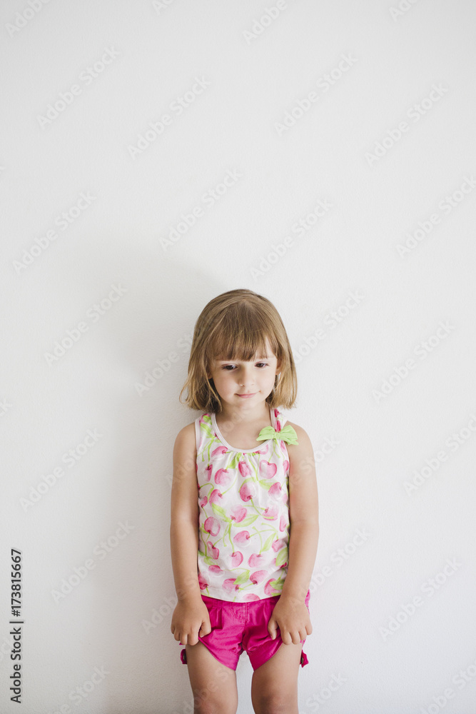 Portrait of shy little girl leaning against the wall Portrait of shy little girl leaning against the wall