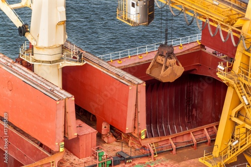 Konstfotografi Crane unloads iron ore at the harbor