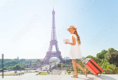 Girl walking around Paris with suitcase and map © Sergey Novikov