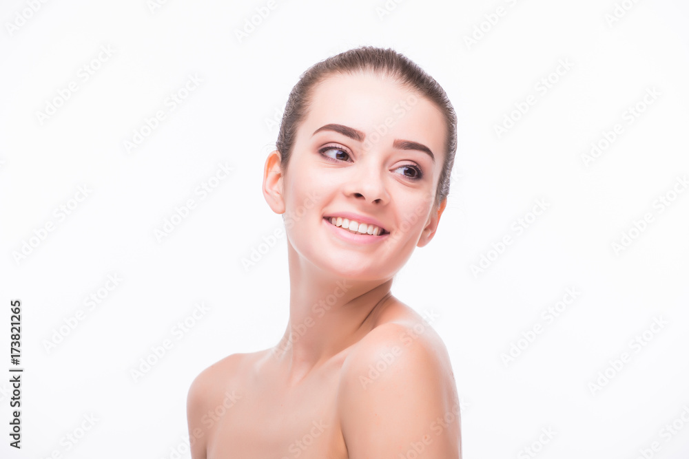 Pretty girl with big eyes and dark eyebrows, with naked shoulders, looking at camera and smiling, a model with light nude make-up, white studio background, beauty photo, copy space, close up. Pretty girl with big eyes and dark eyebrows, with naked shoulders, looking at camera and smiling, a model with light nude make-up, white studio background, beauty photo, copy space, close up.