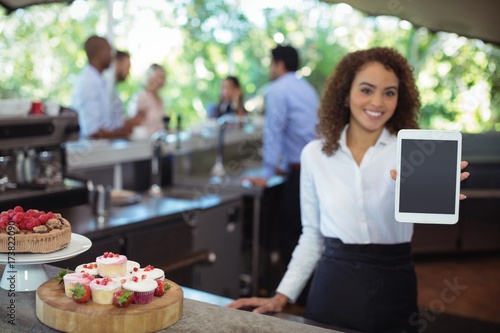 Waitress showing digital tablet at outdoor cafe