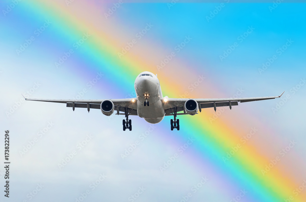 Passenger airplane arrives landing in the rainbow at the airport.