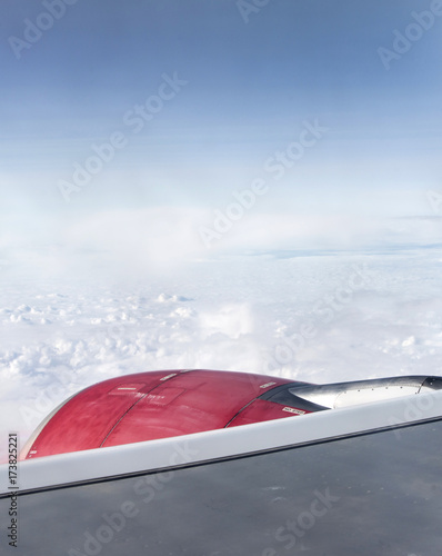 red jet engine turbine look through aircraft window on sunny day blue sky clouds