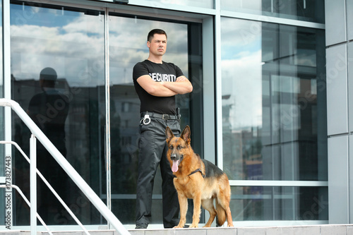 Security guard with dog near building