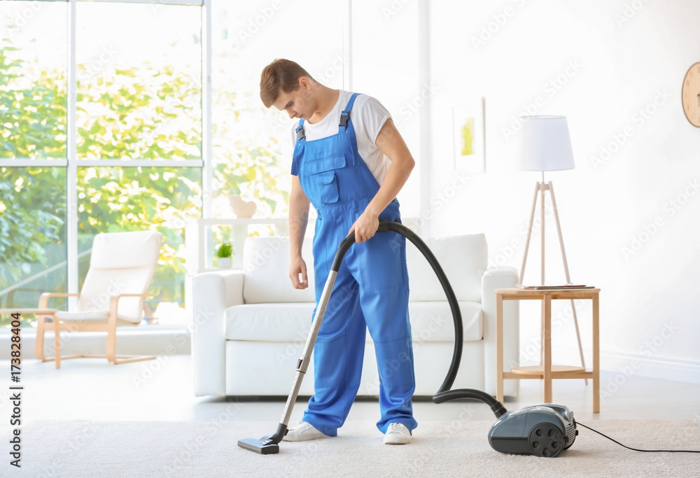 Man cleaning white carpet with vacuum in living room Man cleaning white carpet with vacuum in living room