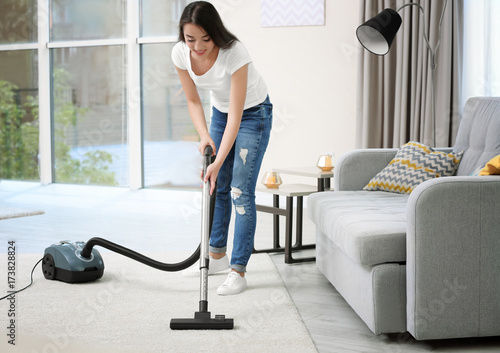 Woman cleaning carpet with ...