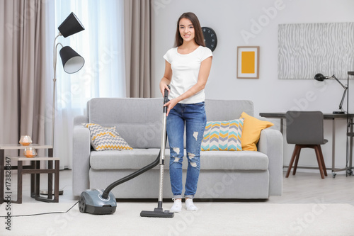 Woman with vacuum in living...