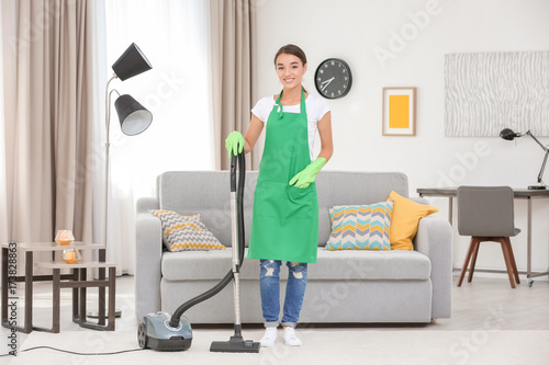 Woman with vacuum in living room