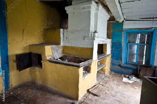 Interior of an abandoned Russian rural house, Russian stove.