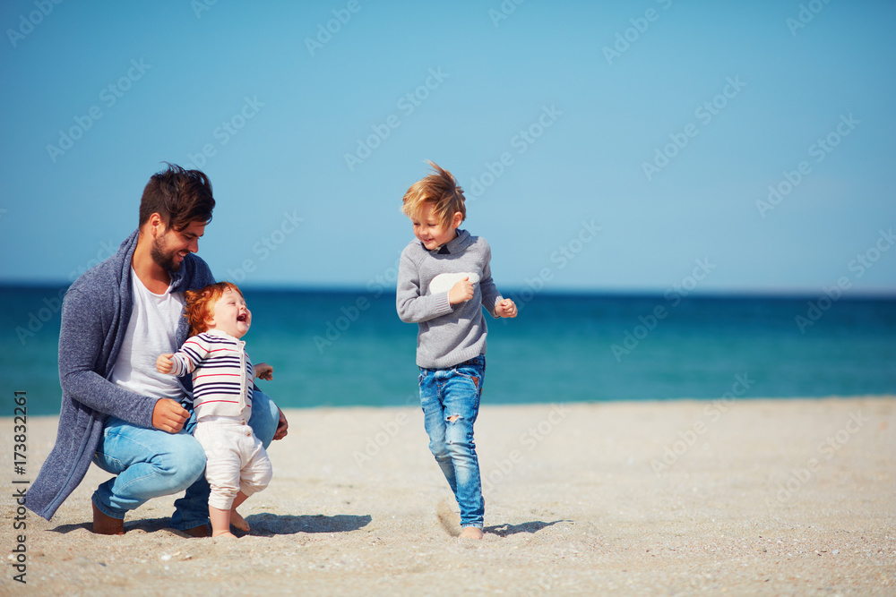 father and sons having fun, running on the sandy beach father and sons having fun, running on the sandy beach