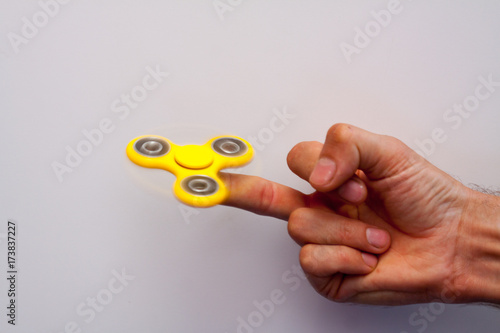 Yellow spinner spinning in the hands of a teen toy to relieve stress and calm the nerves of the sick