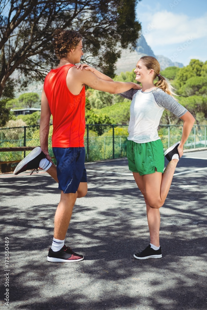 Man and woman stretching on road Man and woman stretching on road