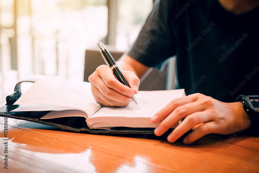 Young asian man hand writing on notebook. Young asian man hand writing on notebook.