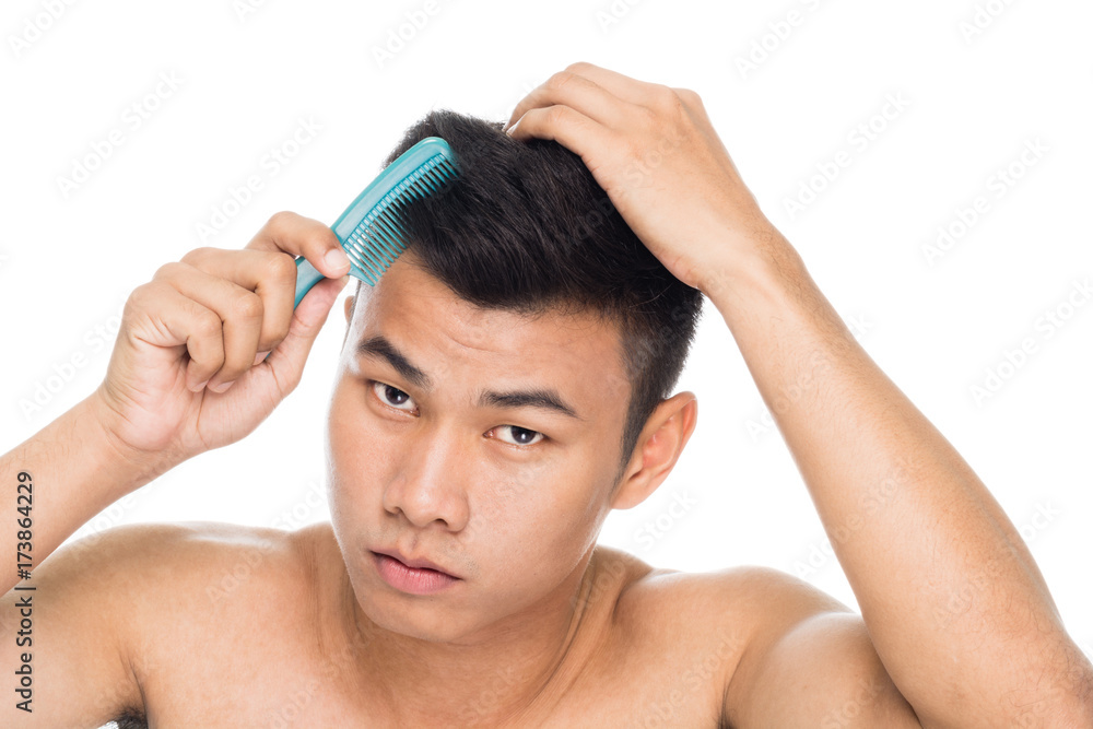 Naklejka premium Handsome man brushing hair with comb close up portrait studio on white background