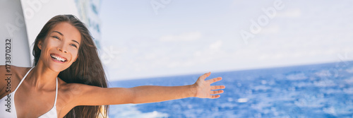 Cruise ship vacation travel fun freedom woman. Asian tourist girl on holidays feeling free with open arms towards ocean water on Caribbean getaway holiday.