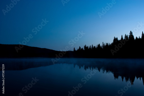 nighttime landscape with reflection on a lake