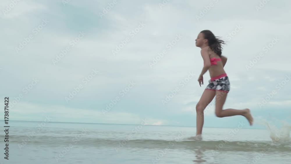 Joyful happy young girl running on water sea spray slow motion stock footage video Joyful happy young girl running on water sea spray slow motion stock footage video