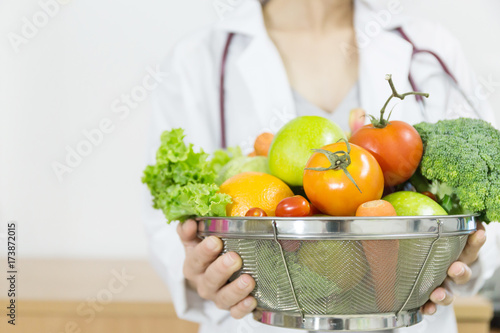 Fototapeta Naklejka Na Ścianę i Meble -  Doctor holding basket of fruits and vegetables with heart healthy foods .