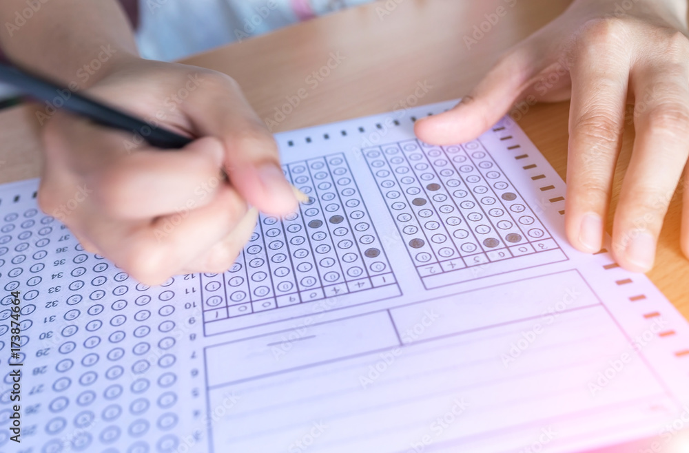 Selective focus Student filling out answers to a test with a pencil.