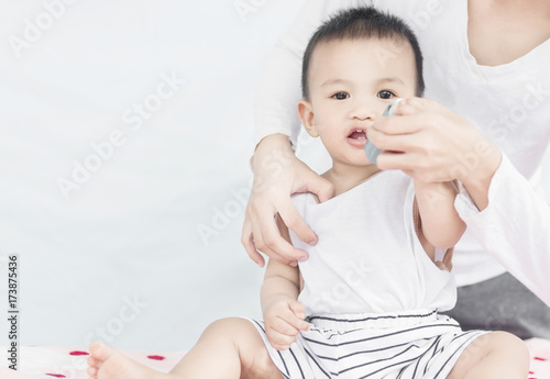 Selective focus Woman using Asthma inhaler for her son. photo