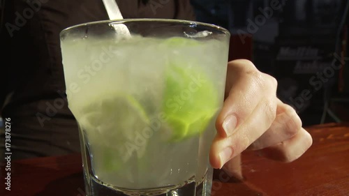 Caipiroska coktail. The bartender mixes the cocktail. photo