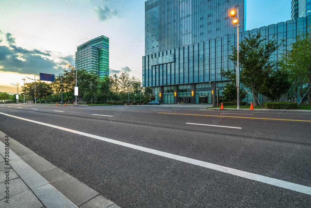 empty asphalt road front of modern buildings at dusk