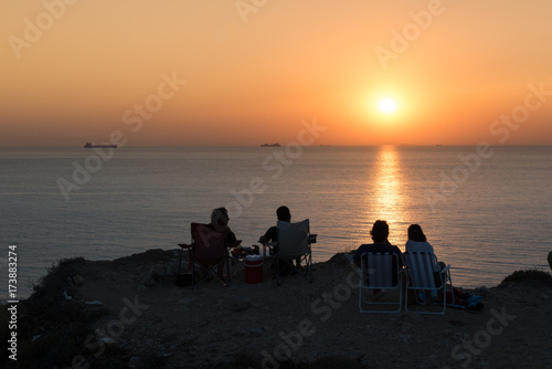 Unidentified people wait for sunset at Bozcaada,Turkey