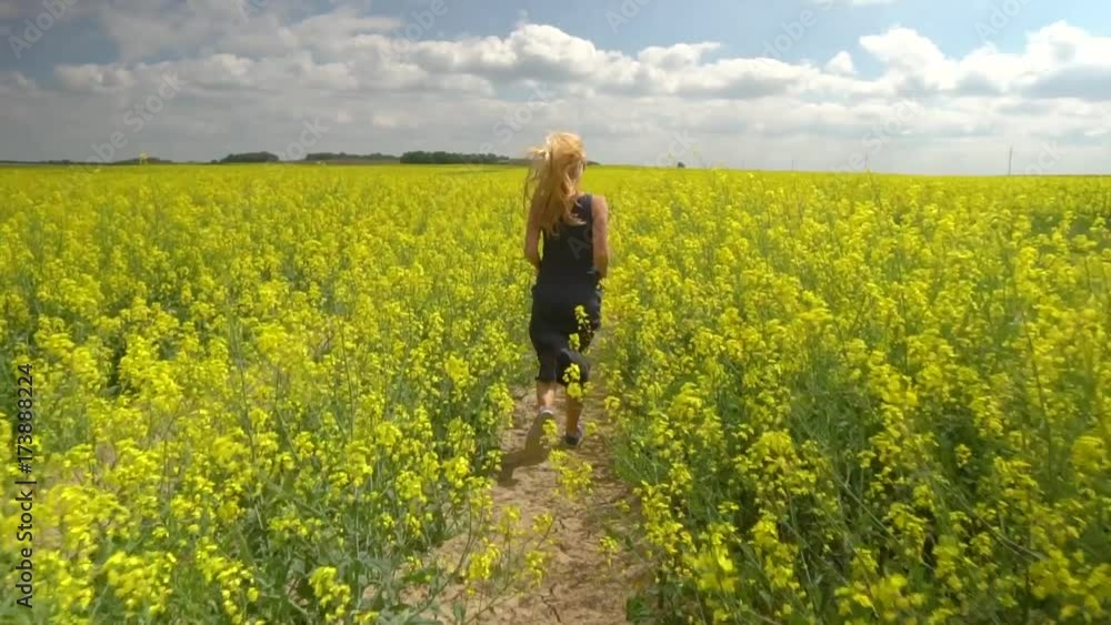 young blonde woman posing in beautiful rapeseed field young blonde woman posing in beautiful rapeseed field