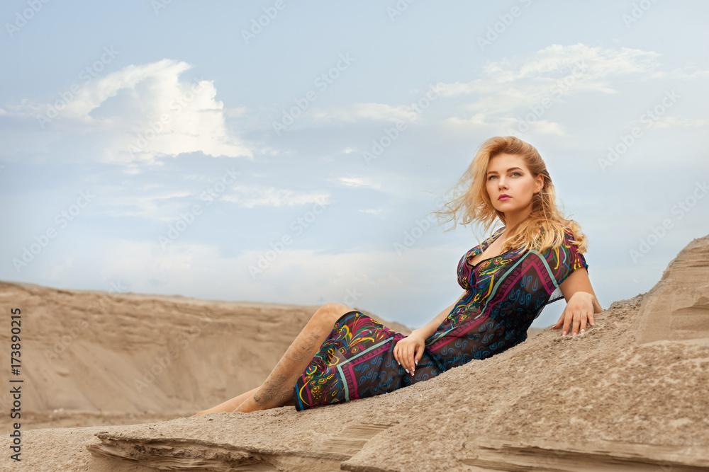 Beautiful woman dreams in the desert lying on the sand, she thought.