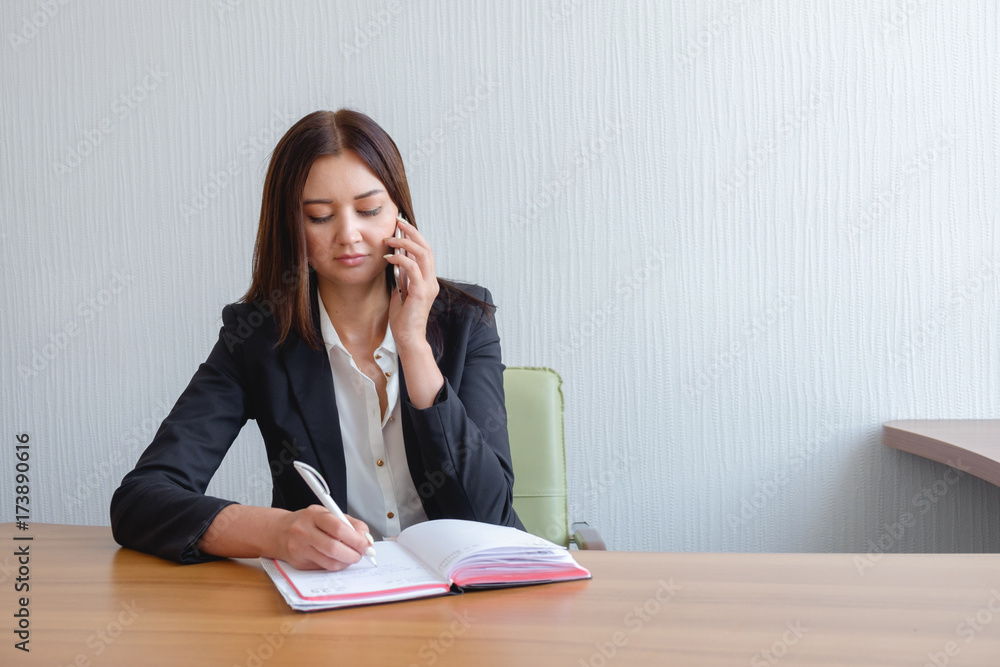 busy secretary is answering call and writing memo at the same time busy secretary is answering call and writing memo at the same time