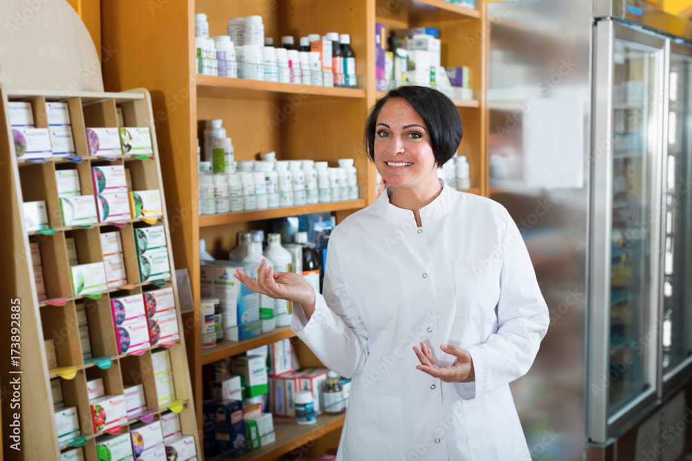 Woman seller in uniform standing with dietary supplements