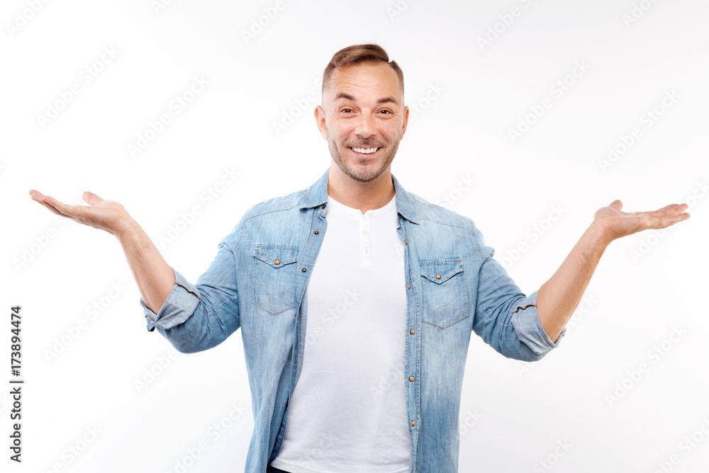 Cheerful young man spreading his hands in amazement Cheerful young man spreading his hands in amazement