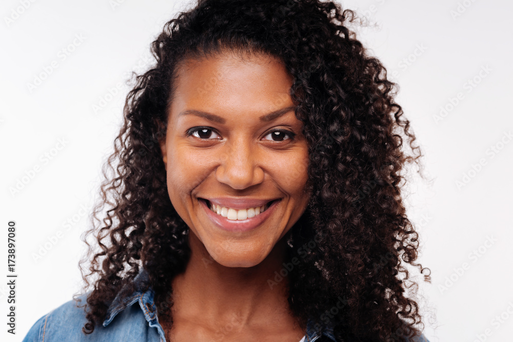 Close up of pretty curly woman smiling at camera Close up of pretty curly woman smiling at camera