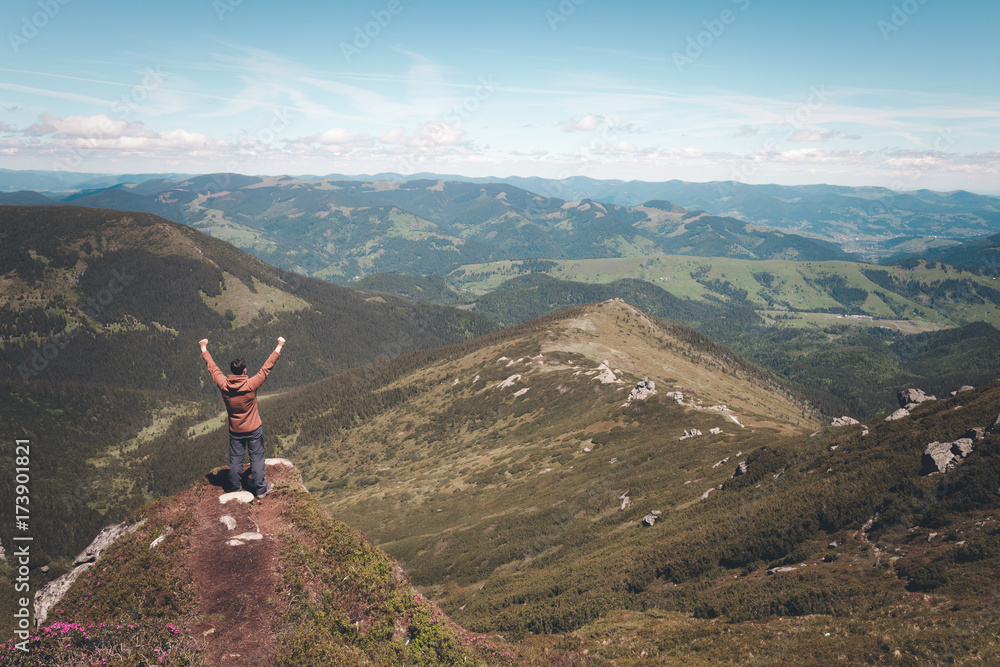 Man standing on the mountain top and looking at horizon