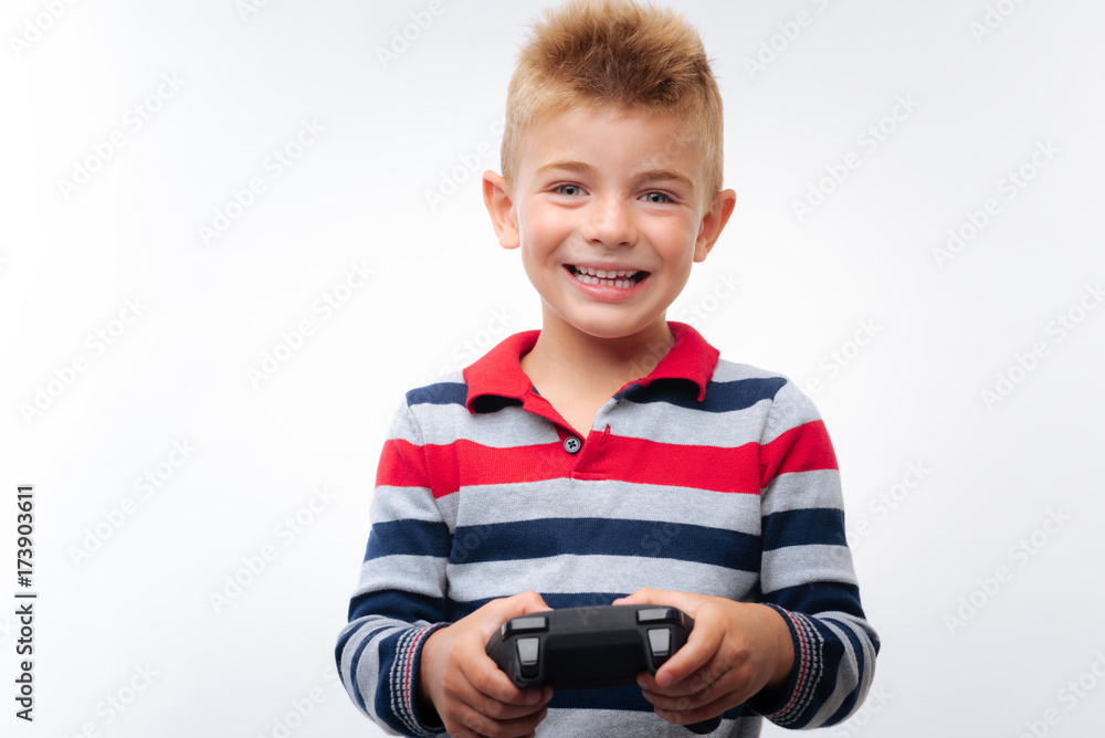Cheerful fair-haired boy playing video game Cheerful fair-haired boy playing video game